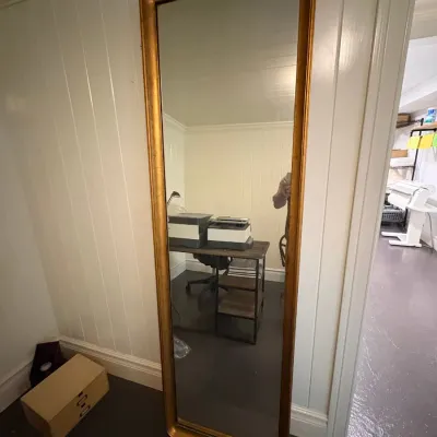 Sale Photo Thumbnail #160: Tall full-length floor mirror featuring a gilded gold-tone frame with rounded corners.