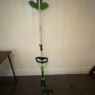 Sale Photo Thumbnail #141: Greenworks cordless string trimmer with dual battery charger and two rechargeable batteries.
