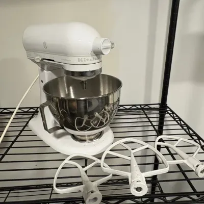 Sale Photo Thumbnail #148: White KitchenAid Ultra Power tilt-head stand mixer with a stainless steel mixing bowl and three white paddle attachment beaters.