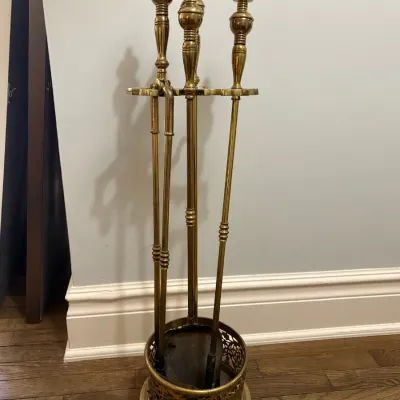Sale Photo Thumbnail #107: Polished brass fireplace tool set featuring decorative urn finials and a pierwork base.