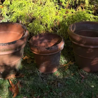 Sale Photo Thumbnail #152: Set of three large, weathered terracotta outdoor planters in graduating sizes.