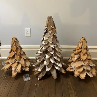 Set of three rustic tabletop Christmas tree decorations crafted from natural birch wood slices.