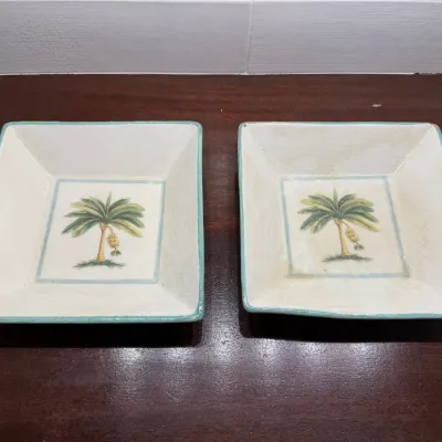 Pair of square ceramic bowls featuring central palm tree motifs with light blue trimmed edges.