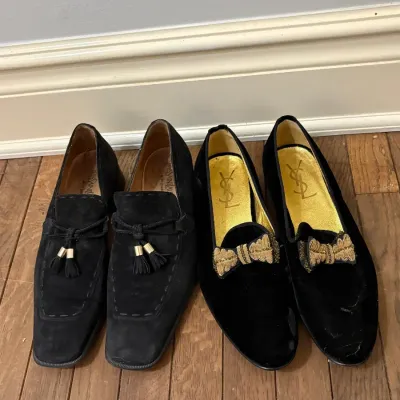 Sale Photo Thumbnail #104: Two pairs of vintage Yves Saint Laurent men's black shoes, including suede tassel loafers and velvet smoking slippers with embroidered gold bows.