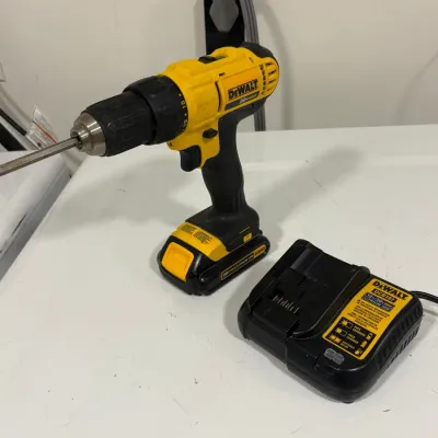 Sale Photo Thumbnail #142: DeWalt 20V Max cordless power drill driver with battery pack and accompanying DCB107 charger, showing moderate surface wear from use.
