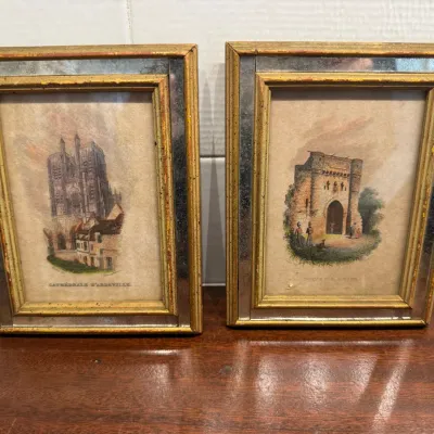 Pair of vintage framed architectural prints featuring French landmarks, housed in giltwood frames with mirrored inner borders.