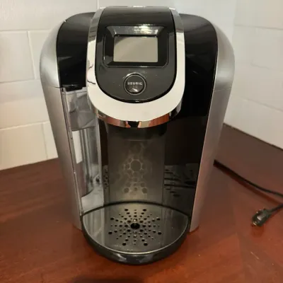 Keurig 2.0 single-serve coffee maker in black and silver plastic with a touch screen interface.