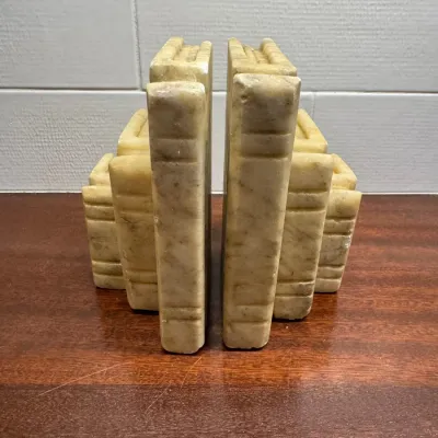 Pair of carved stone or alabaster bookends in the shape of stacked books.