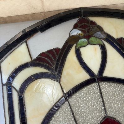 Sale Photo Thumbnail #327: A 3-panel hinged stained glass fireplace screen featuring an intricate Art Nouveau floral/fan pattern in shades of deep red, green, cream, and textured clear glass. Heavy leaded metal framework with hinges connecting the side panels to the central arched 