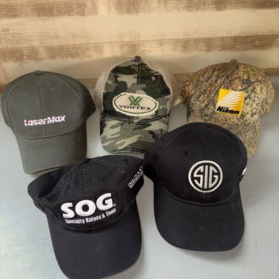 Sale Photo Thumbnail #100: Collection of five branded baseball caps and trucker hats featuring optics, knife, and firearm manufacturer logos. Includes LaserMax (olive green), Vortex (camo mesh back), Nikon (camo), SOG Specialty Knives & Tools (black), and SIG Sauer (black). All ite