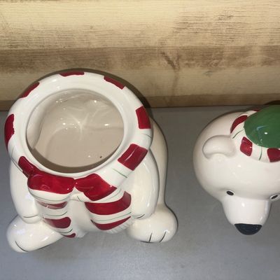 Sale Photo Thumbnail #251: Ceramic holiday cookie jar shaped like a seated polar bear wearing a red and white striped scarf and a green hat. Features a removable head lid with a painted finish. Clean interior, gently used with no visible cracks or chips.
11in tall