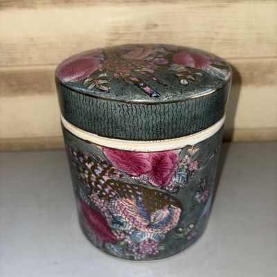 Sale Photo Thumbnail #204: Decorative ceramic lidded container or tea caddy featuring vibrant pink floral motifs and a phoenix/bird design on a dark green textured ground with gold accents. Marked on the bottom 'NOT FOR FOOD USE - ARTICLE MAY POISON THE FOOD - FOR DECORATIVE PURPOS