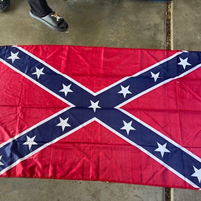 Sale Photo Thumbnail #389: Printed fabric Confederate battle flag featuring stars on a blue saltire over a red field. Includes a white header strip with metal grommets for hanging. Modern construction, light wear from display or storage.
60X36in