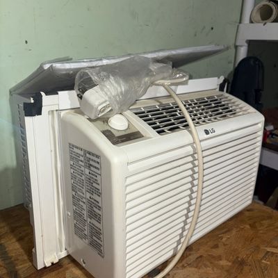 Sale Photo Thumbnail #362: LG white window air conditioner unit featuring top dial/button control panel, power cord with attached plug, and side accordion panels. Shows light cosmetic wear and scuffing from previous use; untested.
21X15X13in