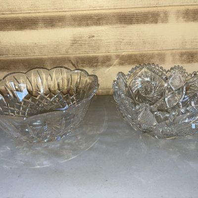 Sale Photo Thumbnail #214: A pair of decorative heavy cut glass or crystal serving bowls with intricate geometric and pinwheel patterns. Both feature scalloped or sawtoothed rims and deep brilliant cut details. In good condition with no visible chips or cracks
4in tall on both.