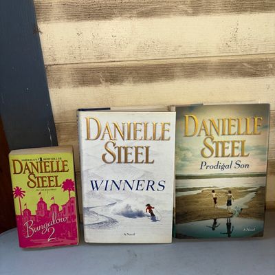 Sale Photo Thumbnail #388: Collection of three Danielle Steel books. Includes two hardcover novels, 'Winners' and 'Prodigal Son', both with dust jackets, and one mass market paperback, 'Bungalow 2'. All items show minor shelf wear and light edge wear, but remain in good readable co