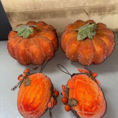 Sale Photo Thumbnail #376: Set of four faux orange pumpkin decorations featuring a sugar-coated or glitter finish with leaves, wire tendrils, and berry details. Includes two larger table-top style pumpkins and two hanging or ornament-style oval pumpkins. Good condition with light w