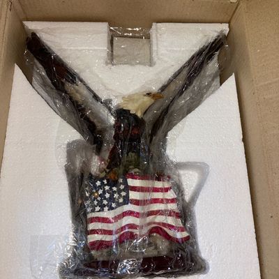 Sale Photo Thumbnail #42: 15X30in.
 Hand-painted resin figurine featuring a bald eagle with wings outstretched behind an American flag design. Item comes stored in its original styrofoam packaging and cardboard shipping box, wrapped in protective plastic. Appears to be in unused o