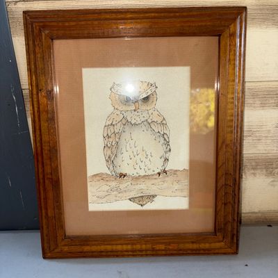 Sale Photo Thumbnail #390: Framed depiction of an owl perched on a branch. Housed in a stained wooden frame with double matting under glass. Appears to be in good pre-owned condition with light wear on the frame.
10X12in