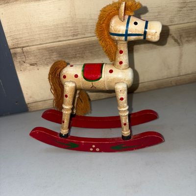 Sale Photo Thumbnail #299: Small vintage hand-painted wooden rocking horse featuring red polka dots, a painted saddle and bridle, red curved rockers, and a yarn mane and tail. Shows light age-appropriate wear and minor surface scuffs.
7in tall