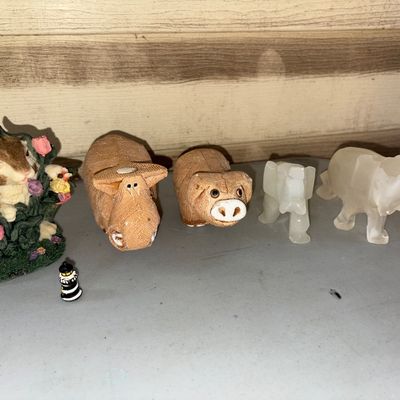 Sale Photo Thumbnail #30: Collection of small decorative animal figurines and a miniature lighthouse. Includes two carved quartz/alabaster style stone elephant figures, two textured ceramic or resin pig/warthog figures, one painted resin bunny with flowers figurine, and one tiny b