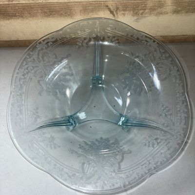 Sale Photo Thumbnail #332: A light blue Depression-style pressed glass bowl featuring an etched floral and ribbon pattern around the rim and body. The interior is divided into three sections with small molded dividers. Supported by three small glass feet. Good condition with no vis