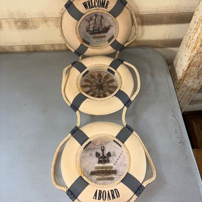 Sale Photo Thumbnail #37: Nautical-themed hanging wall decor featuring three connected life preserver ring sections. Top section reads 'WELCOME' with a ship motif, middle section incorporates a clock with a compass rose dial, and the bottom section reads 'ABOARD' with anchor detai