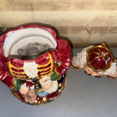 Sale Photo Thumbnail #270: Hand-painted ceramic Christmas nutcracker king cookie jar featuring a removable lid, gold gilt trim details, and toy motifs at the base. Good condition with glossy finish and no visible major chips or cracks.
13in tall