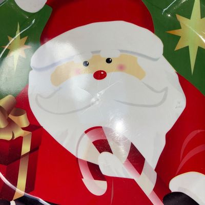 Sale Photo Thumbnail #321: Set of two festive plastic/melamine Christmas serving trays featuring Santa Claus designs. One oval tray with a blue snowy background shows noticeable damage and chipping along the right edge. The second green scalloped tray features Santa holding a prese