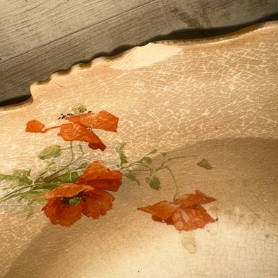 Sale Photo Thumbnail #385: Large antique ceramic or earthenware footed bowl featuring a scalloped rim and a shaded brown-to-tan glaze. Decorated with hand-painted or transfer floral poppy designs on one side and an interior, and a portrait of a monk drinking beer/ale on the opposit