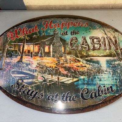 Sale Photo Thumbnail #349: Oval metal novelty wall sign featuring rustic cabin imagery and the text "What Happens at the Cabin... Stays at the Cabin". Features printed faux-rust edge detailing and embossed lettering accents. Good condition with light surface wear.
17X12in