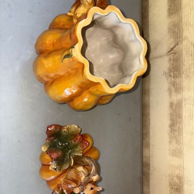 Sale Photo Thumbnail #158: Decorative ceramic pumpkin-shaped cookie jar or lidded canister featuring molded squirrels, autumn leaves, and a stem handle on the lid. High-gloss glazed finish in warm yellow, orange, green, and brown tones. Includes removable lid. Excellent condition w