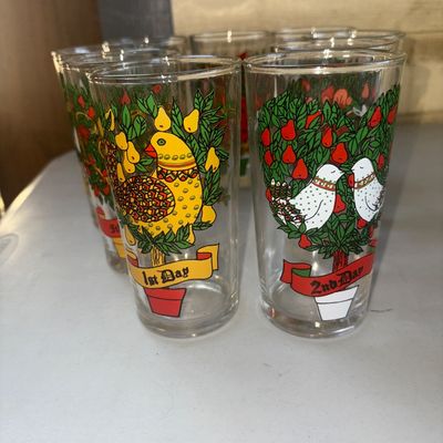 Sale Photo Thumbnail #283: Set of vintage clear glass drinking tumblers featuring colorful illustrations for the Twelve Days of Christmas. Each glass displays a day's verse and corresponding imagery, such as '1st Day' with a partridge in a pear tree and '2nd Day' with turtle doves.