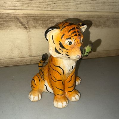 Sale Photo Thumbnail #267: Hand-painted ceramic figurine featuring a seated tiger cub with a green butterfly resting on its nose. Good vintage condition with light surface wear visible on the paws and base.
5in tall