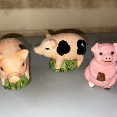 Sale Photo Thumbnail #39: Set of ceramic pig novelties including a pair of spotted pig salt and pepper shakers standing on green grass, along with a small sitting pink pig figurine. Items feature glazed ceramic finishes. Shakers show light glaze wear/imperfections typical of age, 