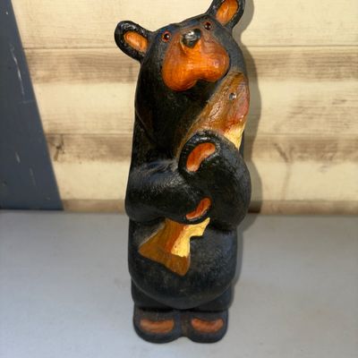 Sale Photo Thumbnail #227: A hand-carved style painted wooden figurine depicting a black bear holding a fish. Features painted orange accents on the snout, ears, paws, and fish. In good condition with minimal signs of wear.
11.5in tall