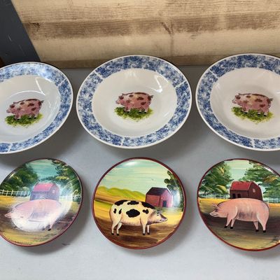 Sale Photo Thumbnail #91: Collection of six pig-themed tableware items, including three shallow ceramic/porcelain bowls with blue sponge-style borders and pig centers, alongside three decorative plates featuring painted farm landscape scenes with pigs. Appears in good pre-owned co