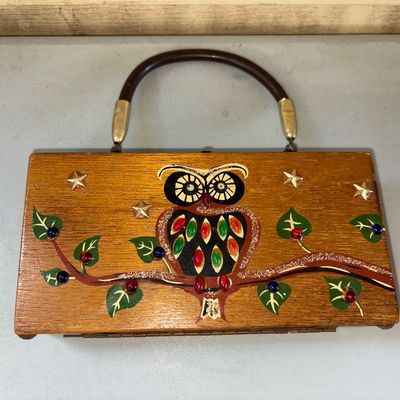 Sale Photo Thumbnail #36: Vintage wooden box handbag featuring a hand-painted and jeweled/beaded owl sitting on a branch surrounded by stars. Includes a curved top handle with brass-tone hardware. Shows light age-appropriate wear to the wood finish and metal components. These bags