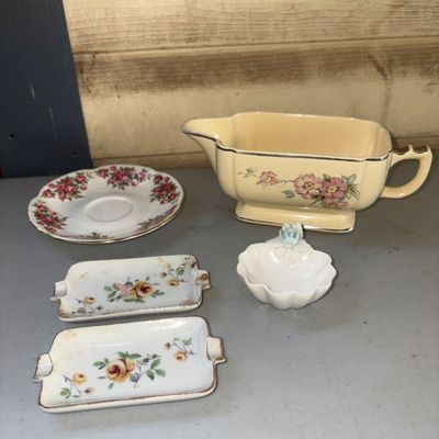Sale Photo Thumbnail #355: Assorted collection of 5 vintage floral porcelain tableware pieces. Includes a cream-colored creamer/sauce boat with pink dogwood blossom motif and gold trim, a small floral saucers, two rectangular floral trinket or ash trays with gold trim, and a small 