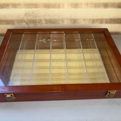 Sale Photo Thumbnail #148: Wooden tabletop display case featuring a hinged glass lid, brass-tone latch closures, acrylic interior dividers, and a mirrored base. Ideal for displaying pocket knives, jewelry, coins, or small collectibles. Shows light scuffs and minor surface wear cons