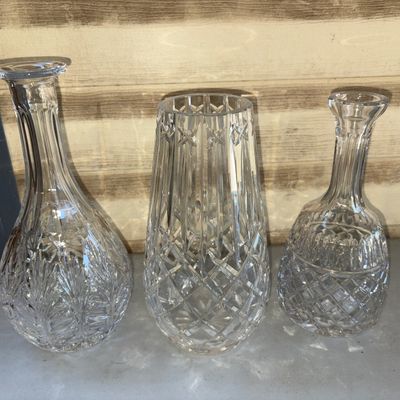 Sale Photo Thumbnail #142: A set of three clear cut crystal glassware pieces, featuring two decanters/bottles with long necks and one tapered vase. All pieces showcase intricate criss-cross and diamond cut patterns. In good condition with no visible chips or cracks.
Middle Vase 9in