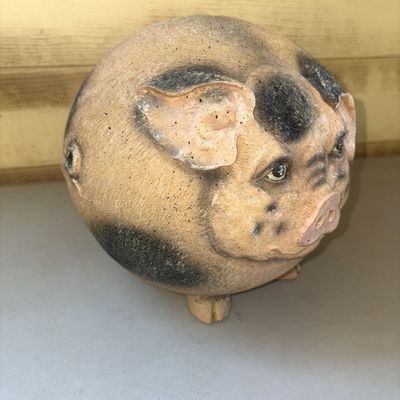 Sale Photo Thumbnail #262: Whimsical round ceramic pig figurine with black spotted details and textured surface. Shows minor paint wear and scuffing consistent with age and display, otherwise in good condition with no major chips or cracks observed.
7in tall