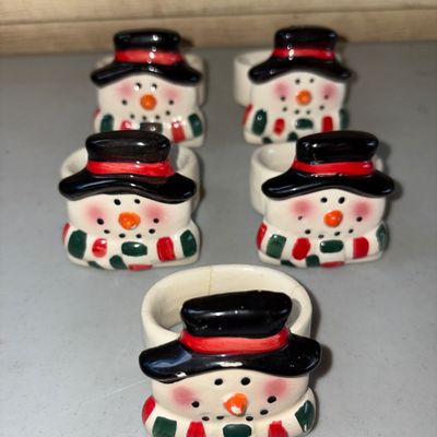 Sale Photo Thumbnail #72: Set of 5 hand-painted ceramic napkin rings featuring festive snowmen with top hats and striped scarves. Showing minor crazing and light surface wear consistent with age and use & small cracks, but overall in good decorative condition.