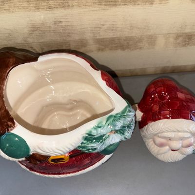 Sale Photo Thumbnail #202: A vintage glazed ceramic Santa Claus cookie jar dated 1998 on the star atop the Christmas tree. Features Santa in a red plaid coat holding a small decorated tree and a toy sack. Two-piece design with removable lid/head. Glazed finish in vibrant reds, gree