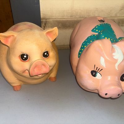 Sale Photo Thumbnail #264: Pair of ceramic piggy banks featuring painted facial details. One bank is styled with a blue and yellow polka dot scarf around its neck and a coin slot on top. Items show light surface wear and minor discoloration consistent with age and use.
6in tall on 