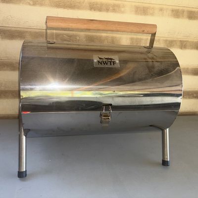 Sale Photo Thumbnail #278: Portable stainless steel tabletop barbecue grill branded with National Wild Turkey Federation (NWTF) logo. Features a wooden carry handle, folding legs, latching lid, and cooking grate inside. Appears clean and unused with paperwork included inside.
15X16