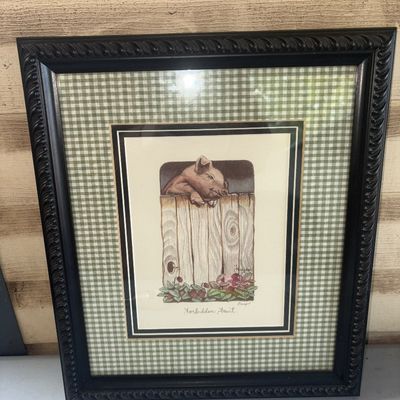 Sale Photo Thumbnail #370: Framed art print titled "Forbidden Fruit" depicting a pig looking over a wooden fence at strawberrries. Features a double-matted design with a green and white gingham outer mat and a decorative black carved-style frame. Presented behind glass. Appears in 