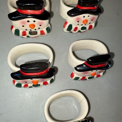 Sale Photo Thumbnail #73: Set of 5 hand-painted ceramic napkin rings featuring festive snowmen with top hats and striped scarves. Showing minor crazing and light surface wear consistent with age and use & small cracks, but overall in good decorative condition.