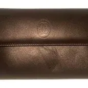 Vintage Cartier burgundy leather flap wallet featuring an embossed double C logo on the front.