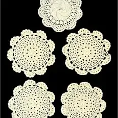 Set of five vintage off-white crocheted lace doilies with scalloped edges.